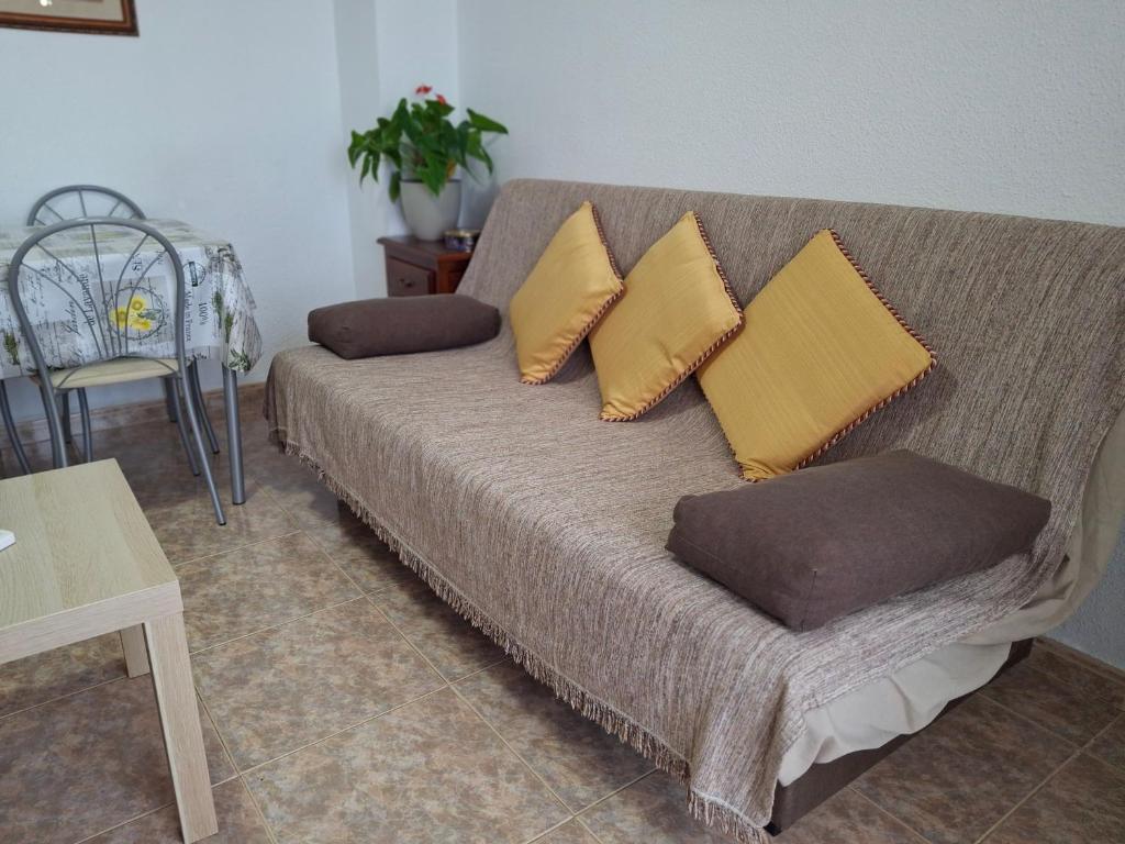 un canapé avec des coussins dessus dans un salon dans l'établissement Corinto, à Benalmádena