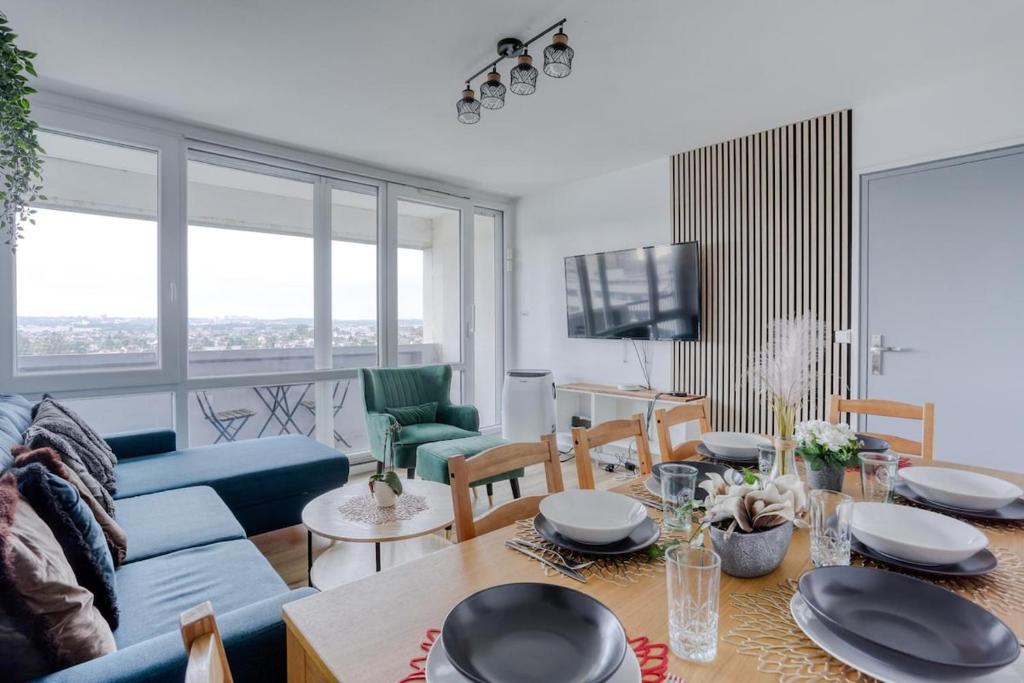 un salon avec un canapé bleu et une table dans l'établissement Large - Paris, DisneyLand, Villepinte Expo, CDG, à Sevran