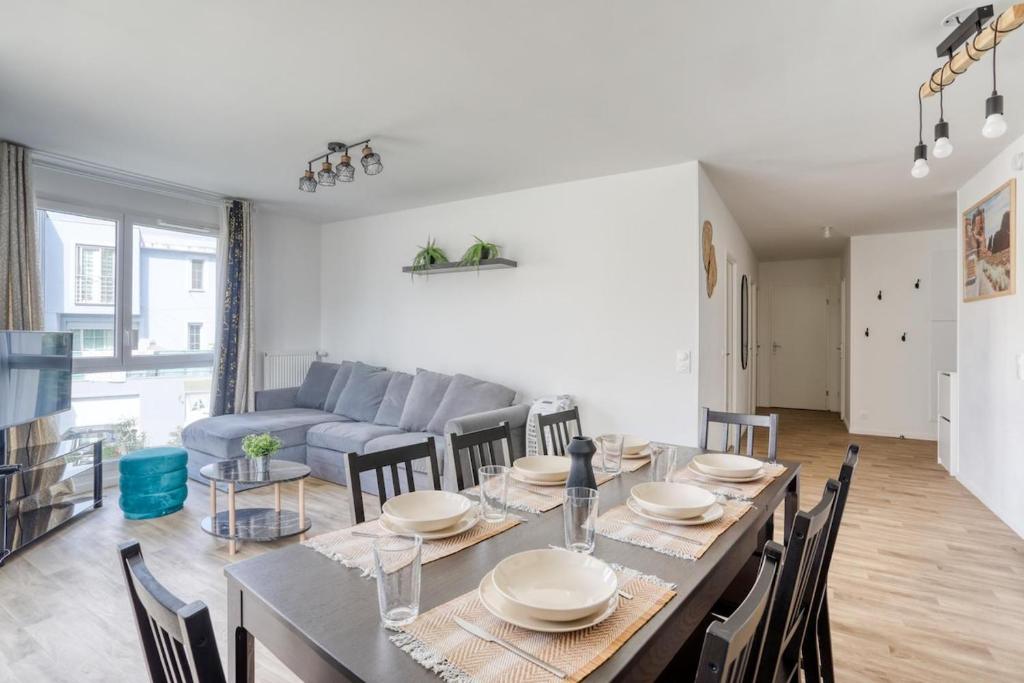 a dining room and living room with a table and chairs at Classic - Paris, DisneyLand, Villepinte Expo, CDG in Sevran