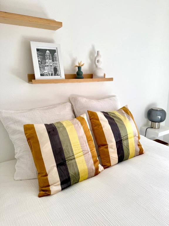 une chambre avec un lit avec deux oreillers dessus dans l'établissement Marseille Longchamp, à Marseille