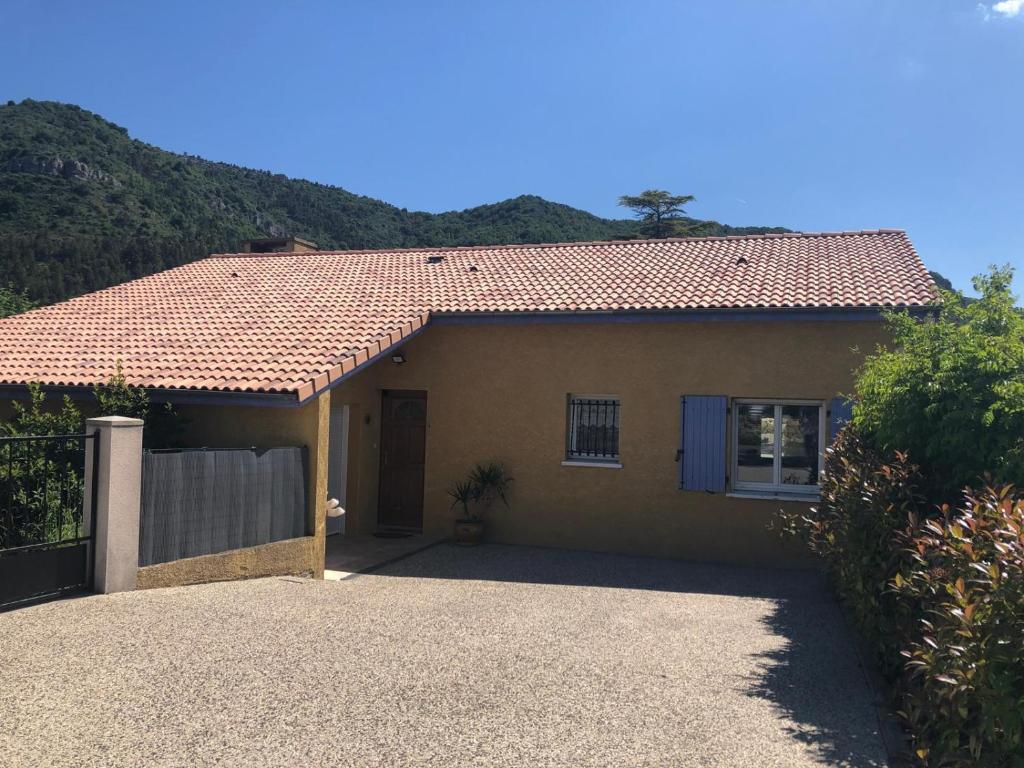 une maison avec une clôture devant dans l'établissement Maison de vacances aux portes de l'Ardèche, à Saint-Julien-en-Saint-Alban