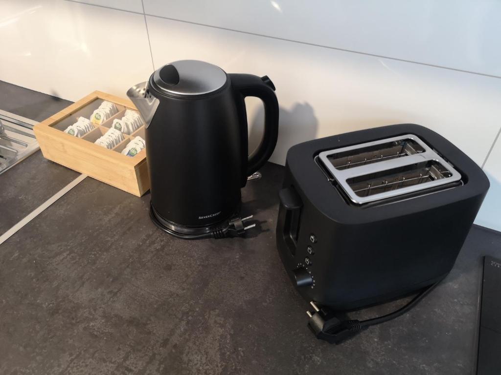 a black coffee maker sitting next to a crate of wine bottles at Happy Place Apartment XXL in Braunschweig