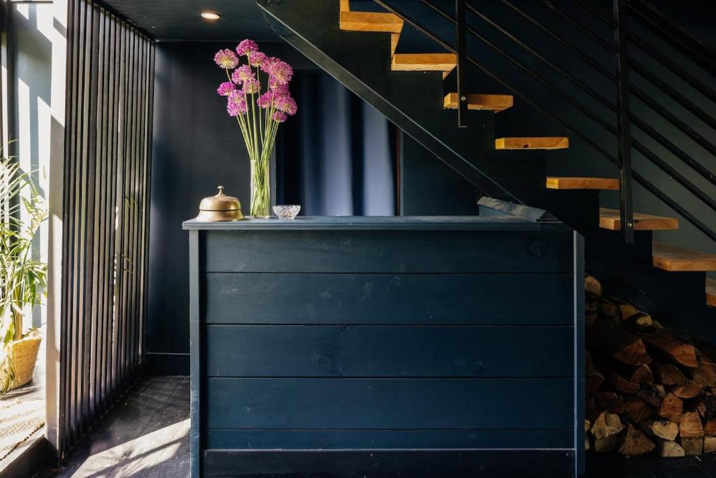 a vase of pink flowers on a table next to a staircase at Suite 001 in Kenoza Lake