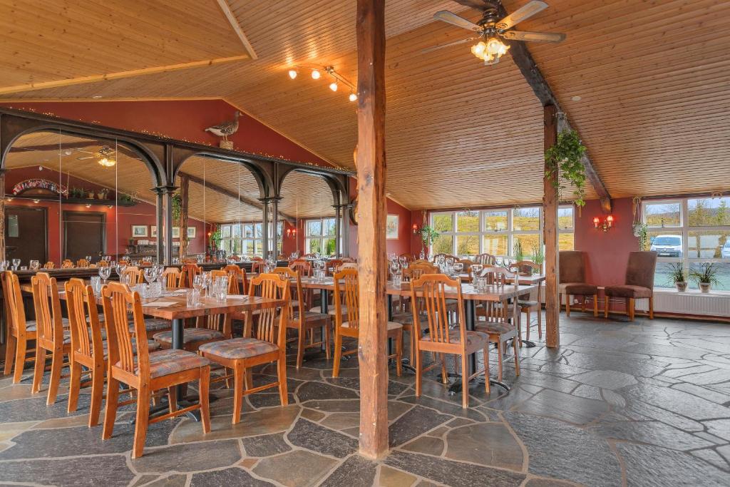 una sala da pranzo con tavoli e sedie in legno di Hestakráin Guesthouse a Selfoss