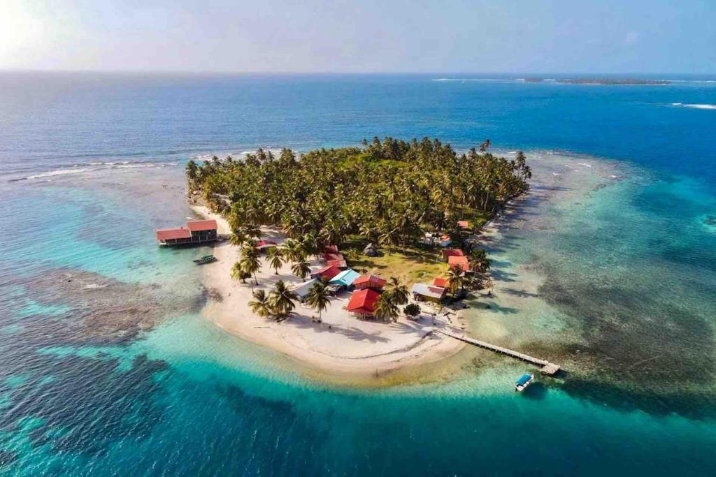 an island in the ocean with a boat in it at Romantic Cabin on Diablo Island San Blas in Panama City