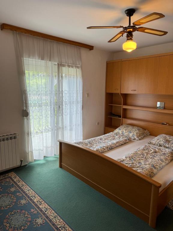 a bedroom with two beds and a ceiling fan at Idas Guesthouse - Kuća na jezeru - Haus am See - Privatunterkunft - Čelebići kod Konjica in Železnička Stanica Ostrožac