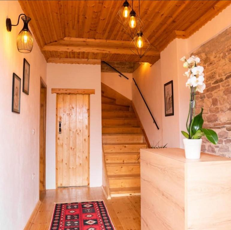 uma escada numa casa com tecto de madeira em Porta7 Hotel em Gjirokastër