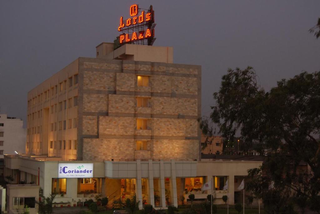 a building with a neon sign on top of it at Lords Plaza Ankleshwar in Ankleshwar