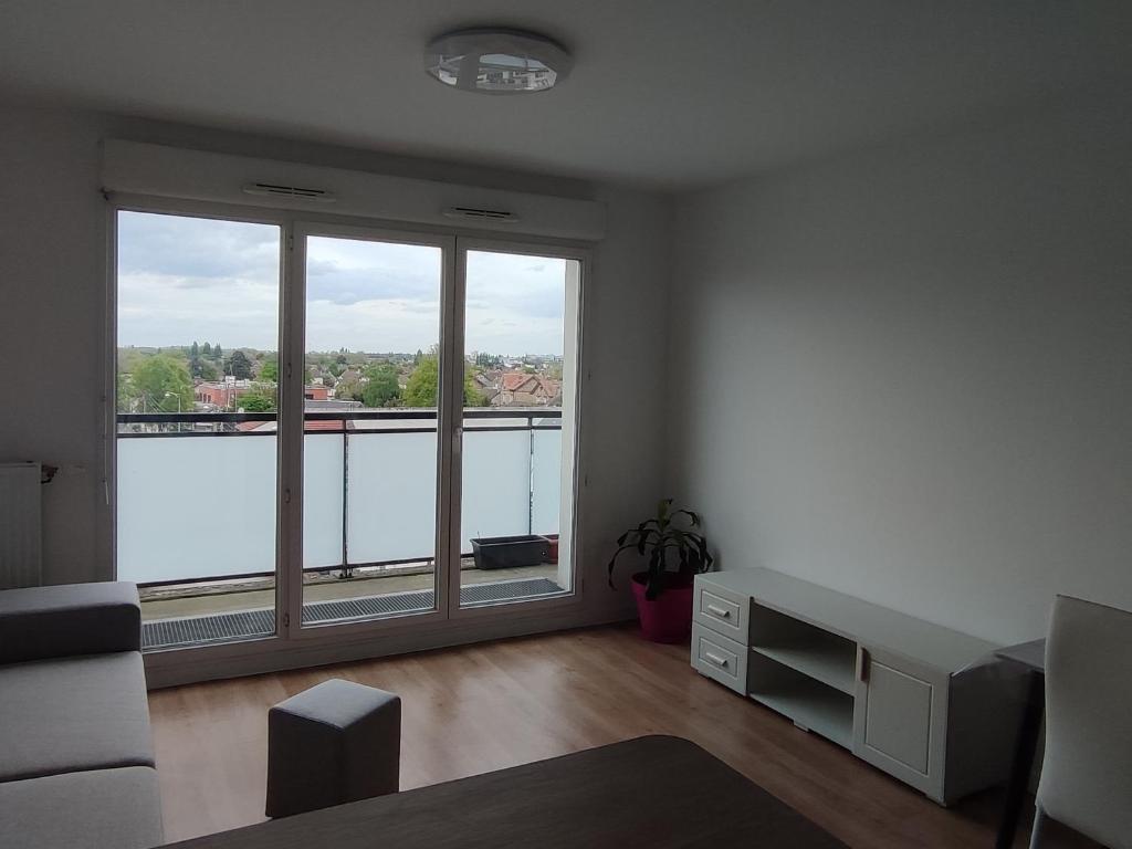 - un salon vide avec une grande fenêtre offrant une vue dans l'établissement 休闲之旅, à Aulnay-sous-Bois