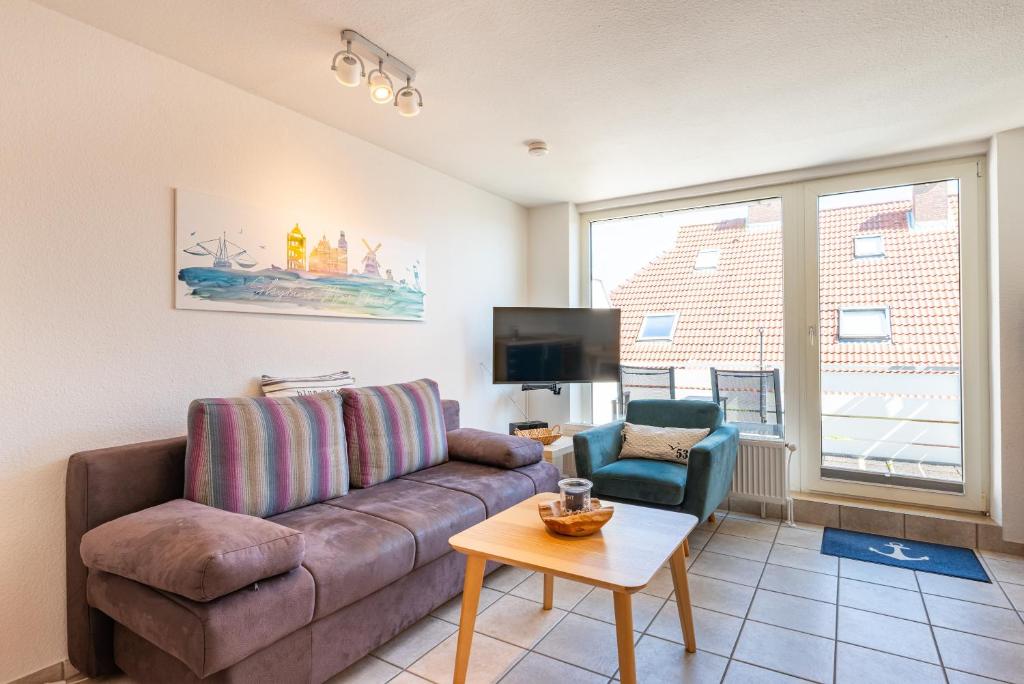 a living room with a couch and a tv at Ankerlicht in Norddeich