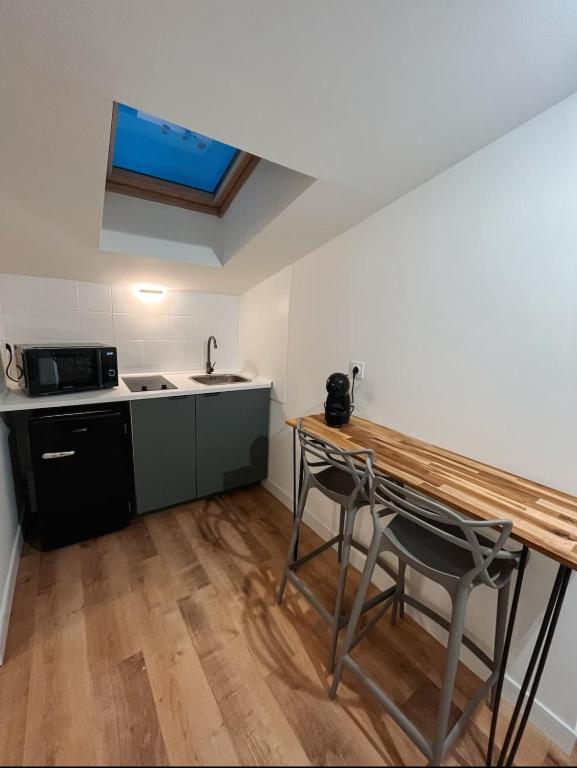 a kitchen with a table and a sink and a microwave at Au cœur des Chartrons in Bordeaux