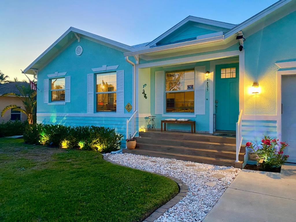 a blue house with a front porch and stairs at Cozy Coastal Cottage at Naples Bay, Pickleball, Botanical Garden in Naples