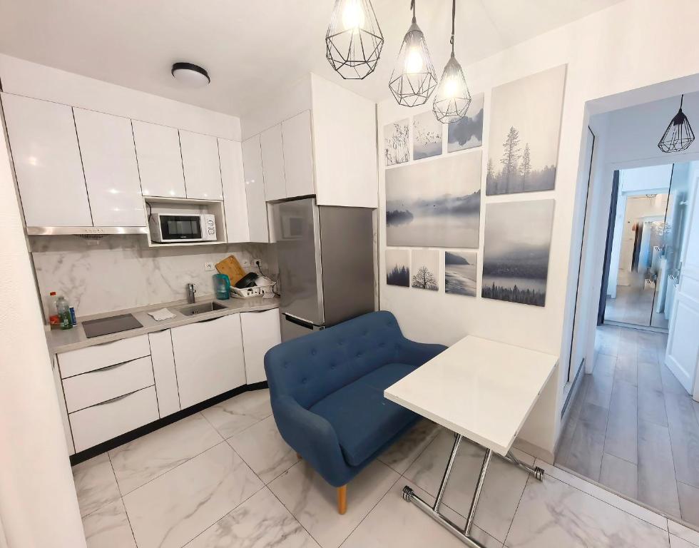 une cuisine avec une chaise bleue et une table dans l'établissement Marais Side Apartment Paris 11e, à Paris