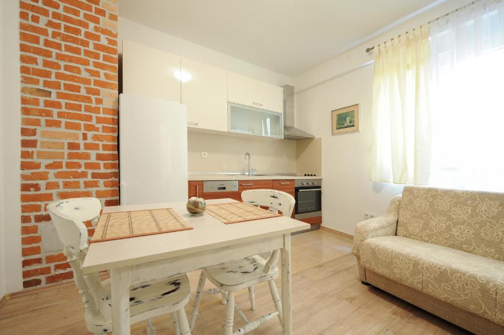 een keuken en een woonkamer met een tafel en een bank bij Little Cosy Apartment in Zadar