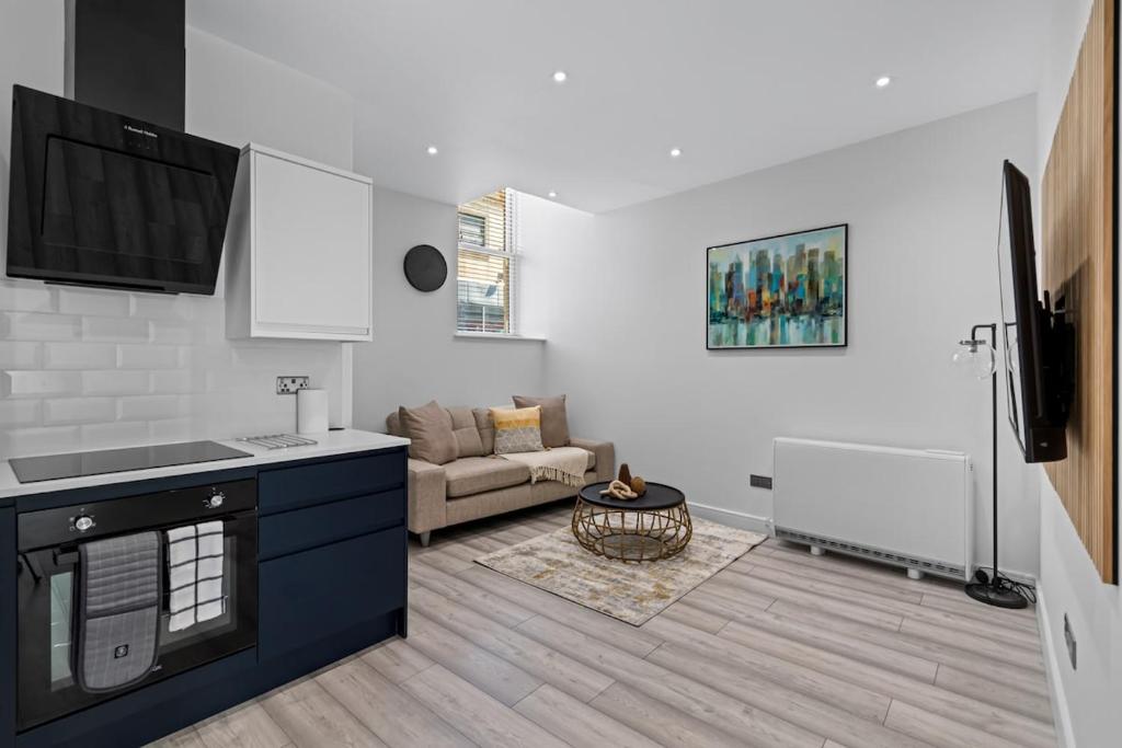 a kitchen and living room with a couch at Serene Haven - 2 min from Station - Free Parking - Courtyard in Swindon