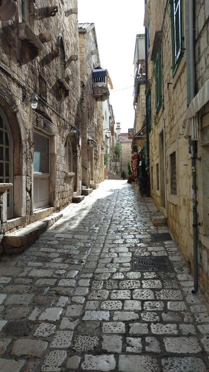 an old stone street in an alley between buildings at Roko's in Hvar