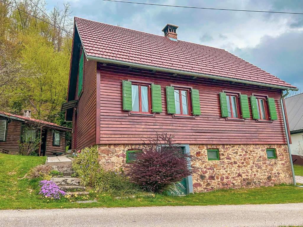 una grande casa di legno con persiane verdi di Holiday house with a parking space Kamenski Hrib, Gorski kotar - 24427 a Plešce