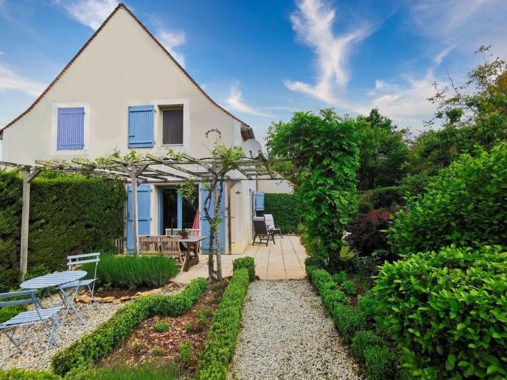 カルサック・アイヤックにあるHoliday Home in Périgord Noir near Dordogneの庭園とパティオ付きのコテージ