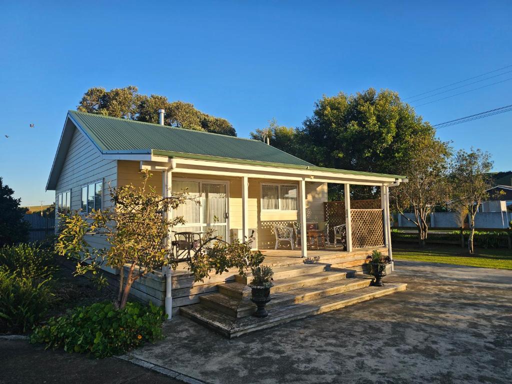 a small house with a porch and a deck at Petane Cottage in Napier