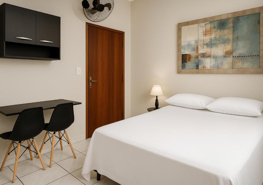 a bedroom with a bed and two chairs and a desk at Quarto Casal Aparecida-SP in Aparecida