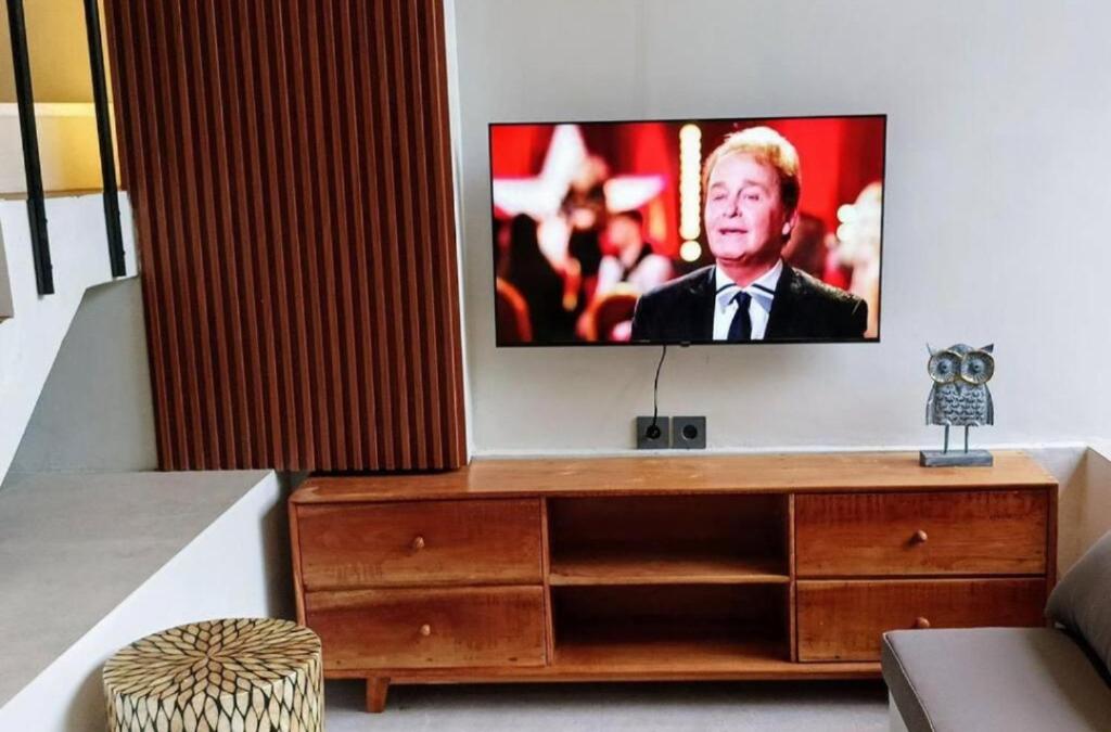 a flat screen tv sitting on top of a wooden dresser at 2 Bedroom Villa In Sanur Harbour in Sanur