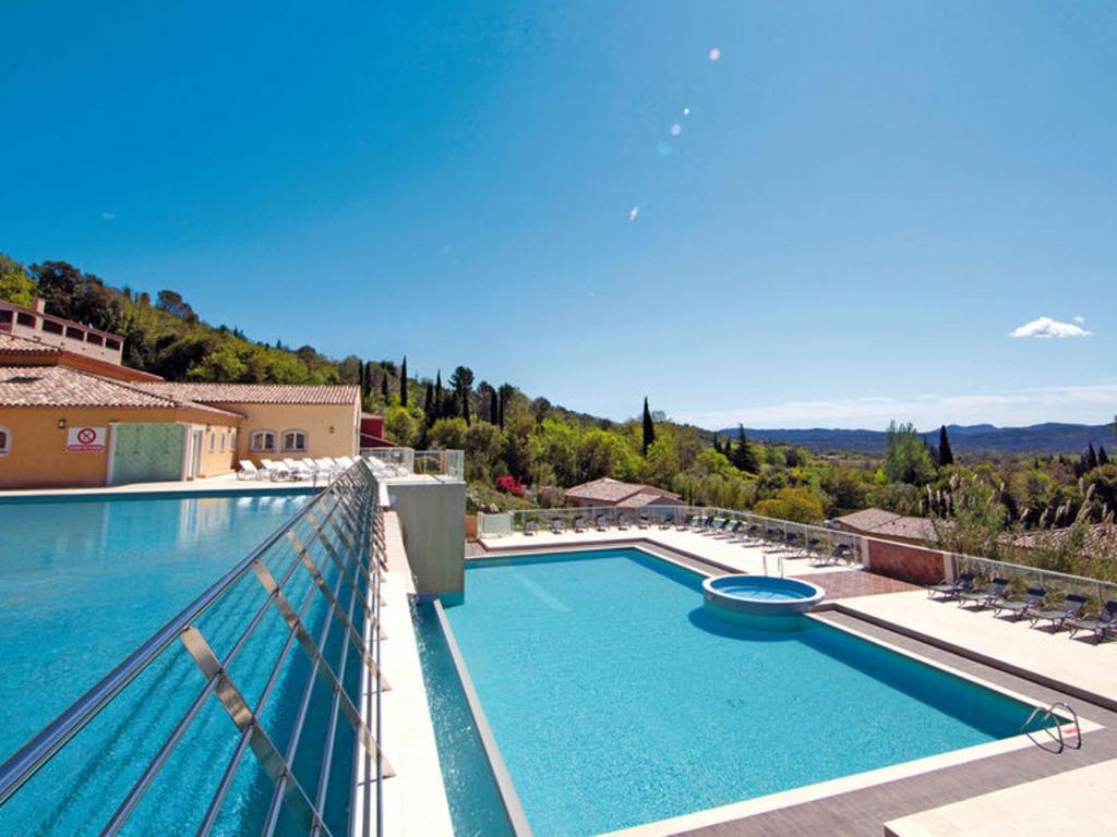 une grande piscine au sommet d'un balcon avec des chaises dans l'établissement Callian : Appartement sécurisé près du Lac, animaux admis - FR-1-779-12, à Callian