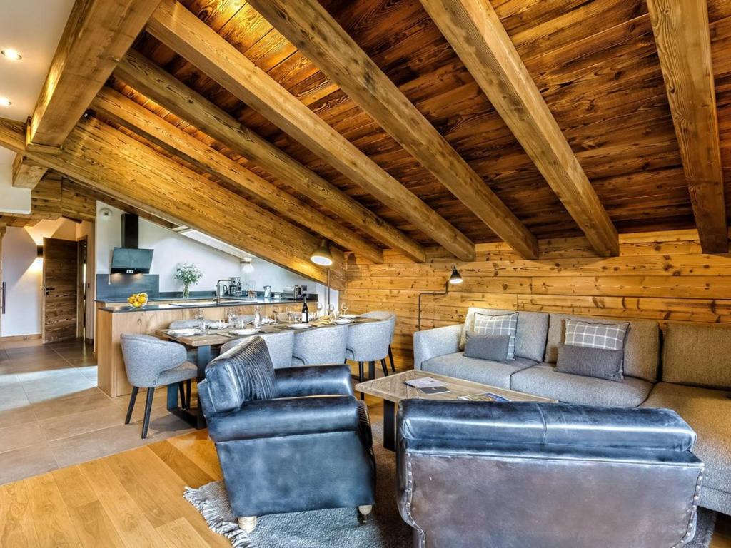 - un salon avec des plafonds en bois, une table et des chaises dans l'établissement Appartement moderne avec jacuzzi et sauna - Les Saisies - FR-1-810-32, à Hauteluce