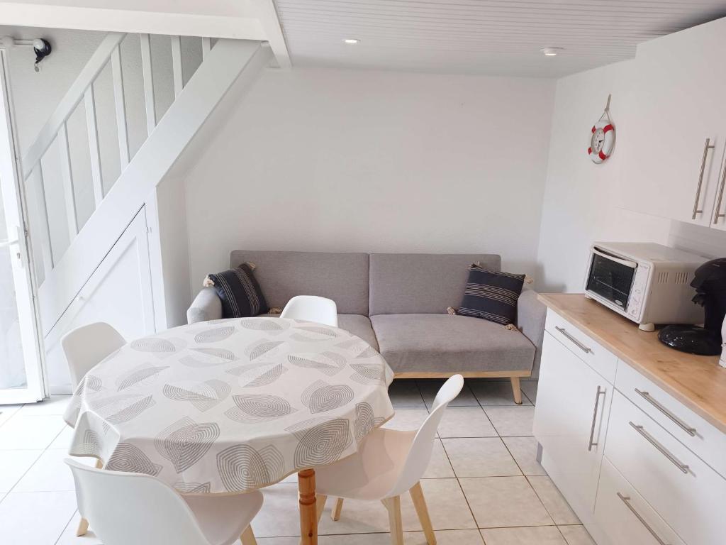 un salon avec une table et un canapé dans l'établissement Maisonnette avec Terrasse, Parking à 800m de la Plage - FR-1-778-36, à Dolus-d'Oléron