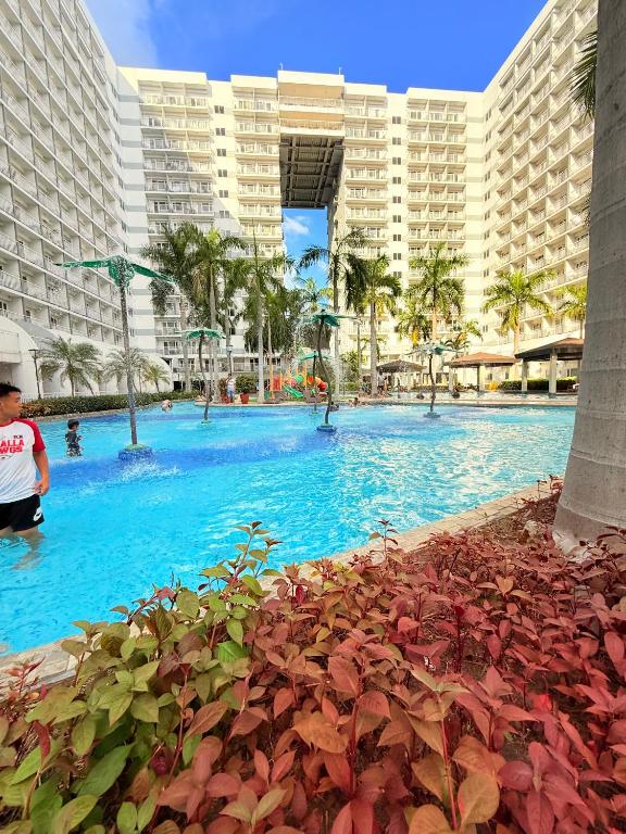 a large swimming pool in front of a large building at Shell Residences Condotel by PauL in Manila