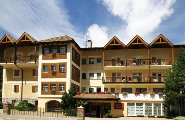 a large building with balconies on top of it at Hotel Villa Rosa in Campitello di Fassa