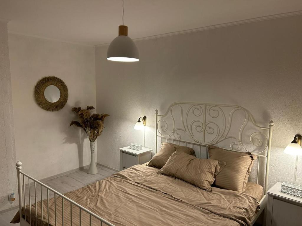 a bedroom with a bed and a mirror and lamps at Apartament 2 dormitoare ultracentral modern in Craiova