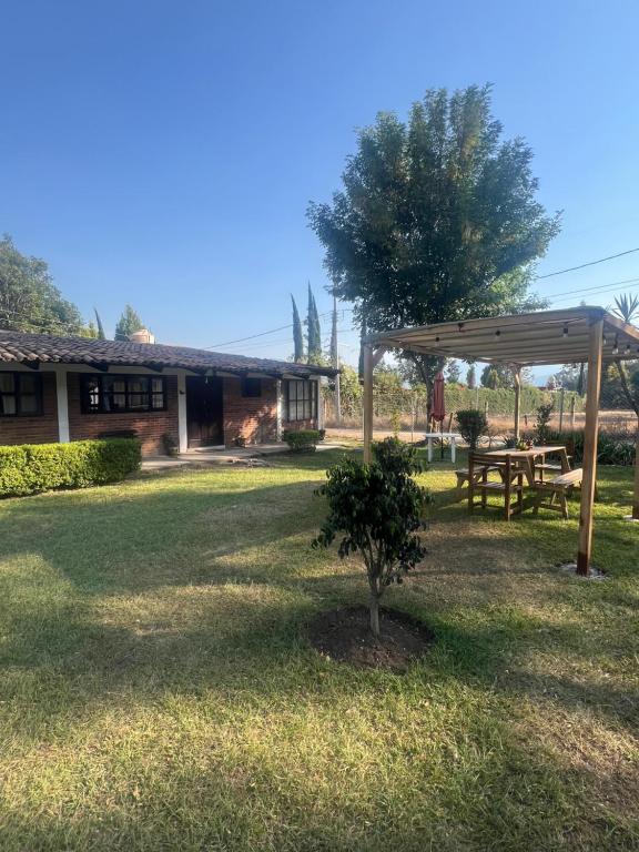 Un refugio para picnic y una mesa de picnic en un patio. en Cabaña cerca del Santuario Valle de Bravo, en Valle de Bravo