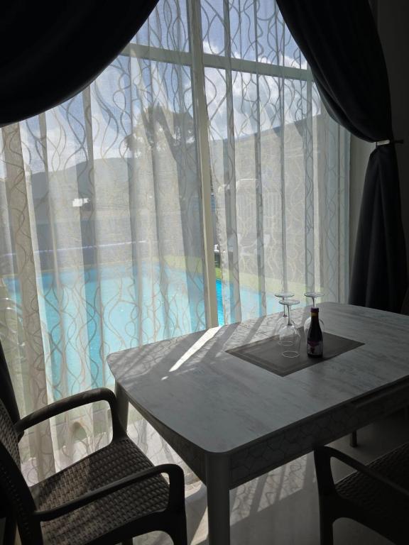 a table and two chairs and a window with a wine glass at שלוות יעקב in Sifsufa