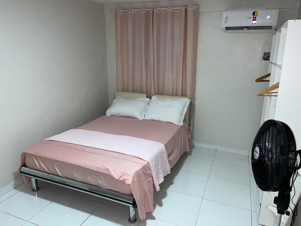 a small bedroom with a bed and a fan at Apto Elegante no Vieiralves in Manaus