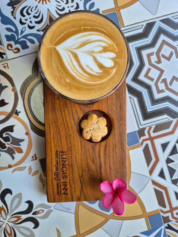 a cup of coffee with a cookie in a dog house at Jungle Inn Bukit lawang in Bukit Lawang