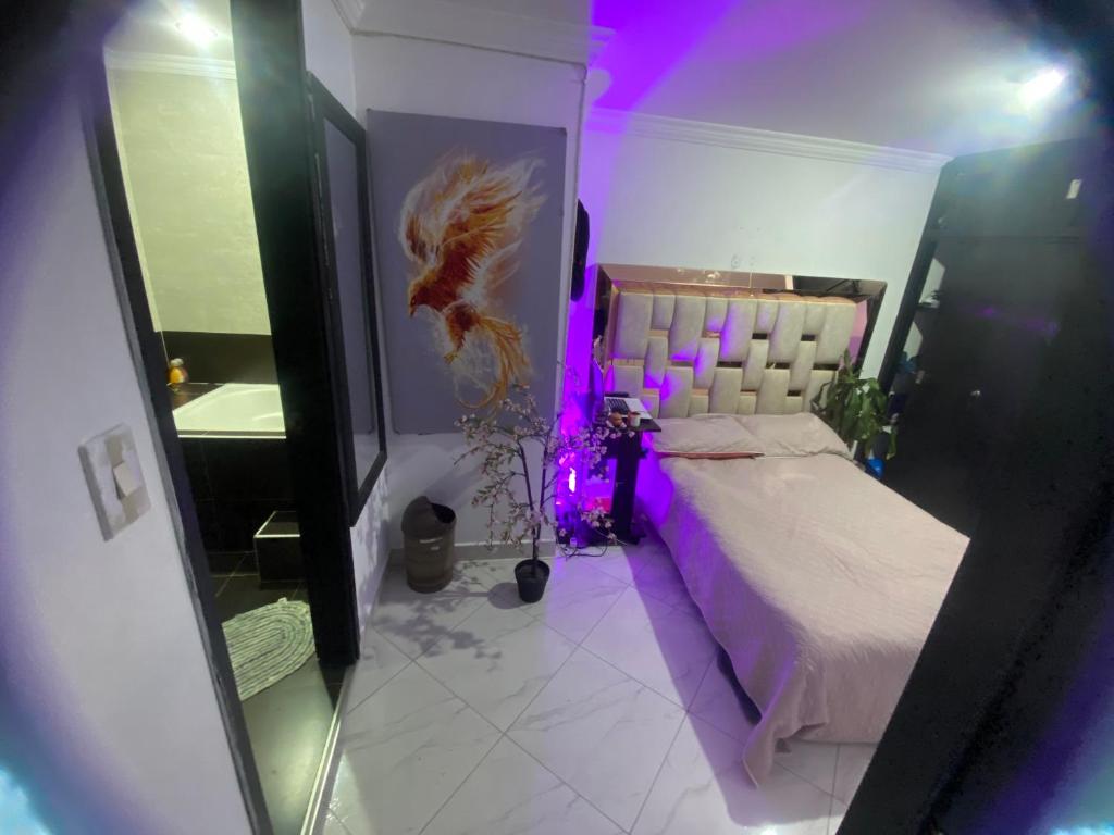 a bedroom with a bed with a purple lighting at Vista espectacular in Medellín