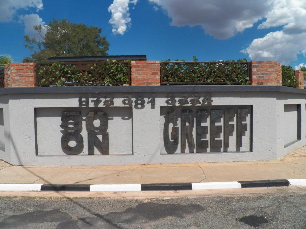 un edificio blanco con graffiti a un lado en 50 ON GREEFF, en Lichtenburg