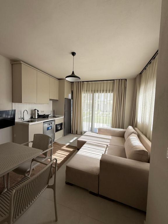 a living room with a couch and a kitchen at Mara Bahçe Alaçatı in Çeşme