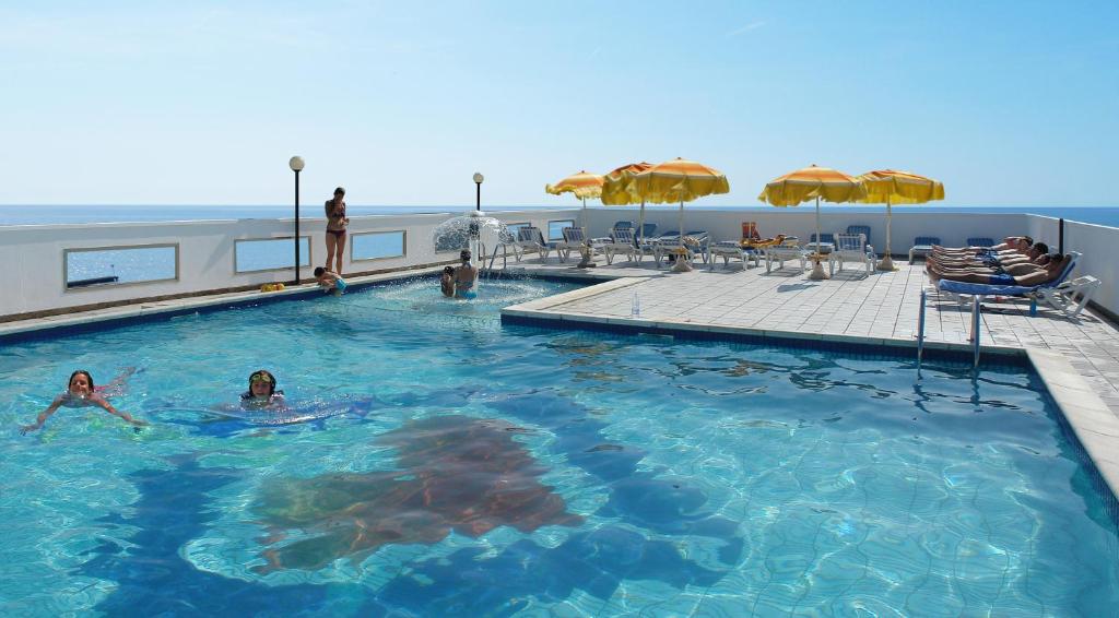 a pool on a cruise ship with people in the water at Hotel Christian in Lido di Jesolo