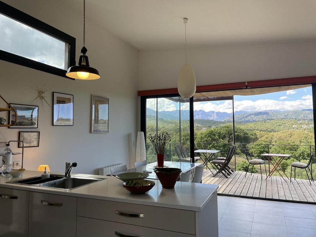a kitchen with a sink and a view of a patio at A Casuccia in Zonza