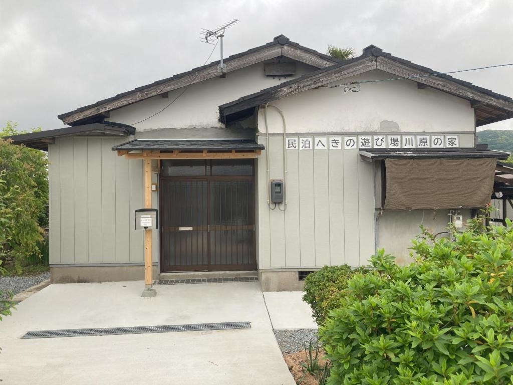 a small white building with a door with a sign on it at Private accommodation Heki playground "Kawahara no - Vacation STAY 94708v in Furuichi