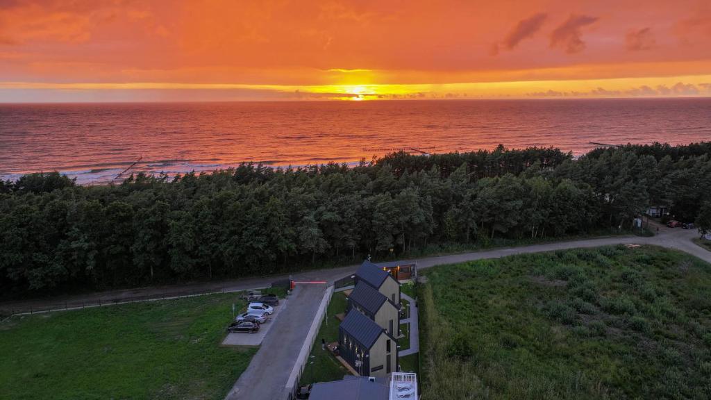 an aerial view of a sunset over the ocean at Baltic Houses domki apartamentowe nad morzem przy plaży in Kopań