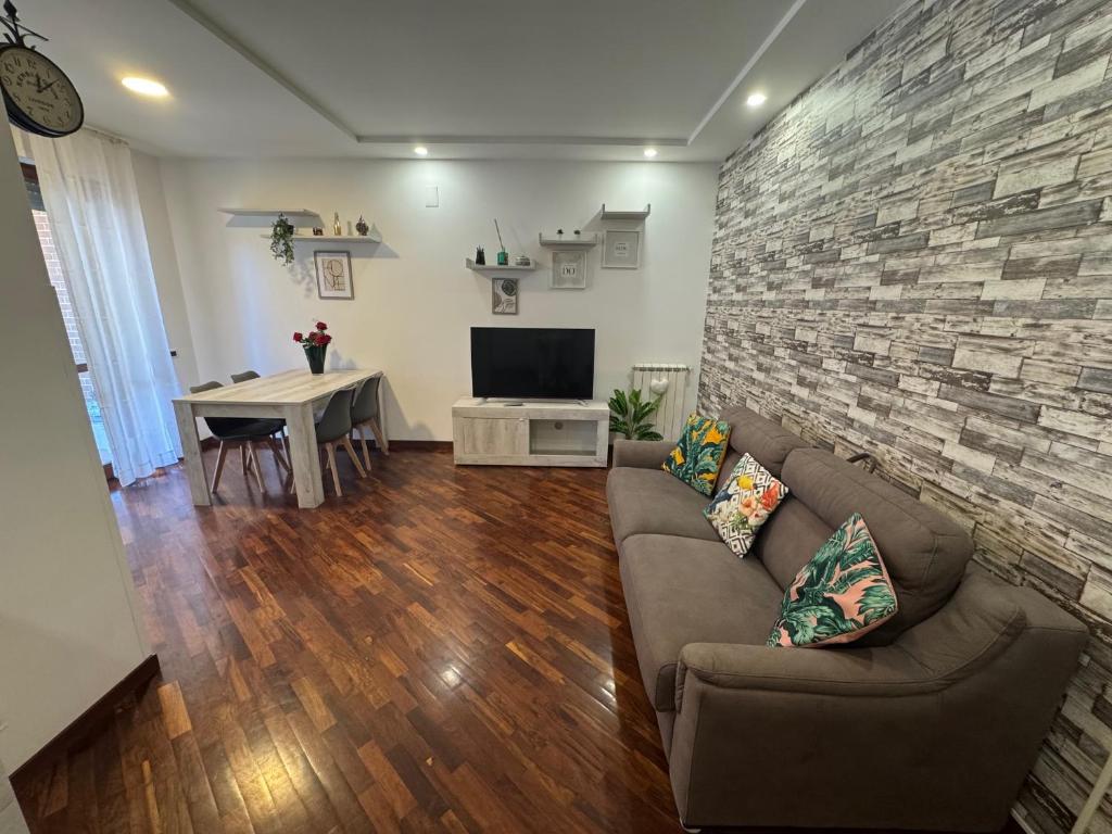 a living room with a couch and a tv and a table at Casa ViDì Fiumicino in Fiumicino Airport