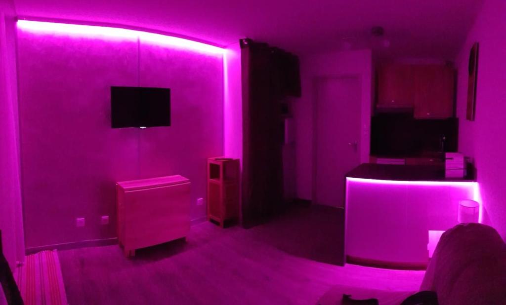 - un salon avec des lumières roses dans l'établissement Pra-Loup 1600 Pied des pistes, à Uvernet