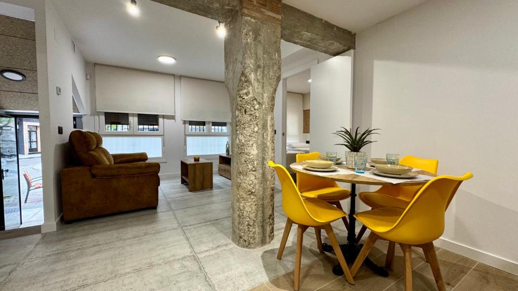 a dining room with a table and yellow chairs at Casa Martina in Zaragoza