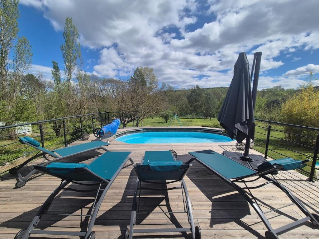 une terrasse avec des chaises et un parasol, ainsi qu'une piscine dans l'établissement Villa Evasion 10 pers Clim, à Saint-Martin-de-Londres