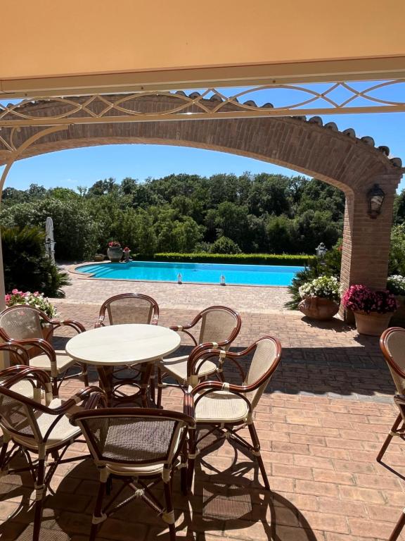 a patio with a table and chairs and a pool at Casale Antica Cassia Luxury & Spa in Rome