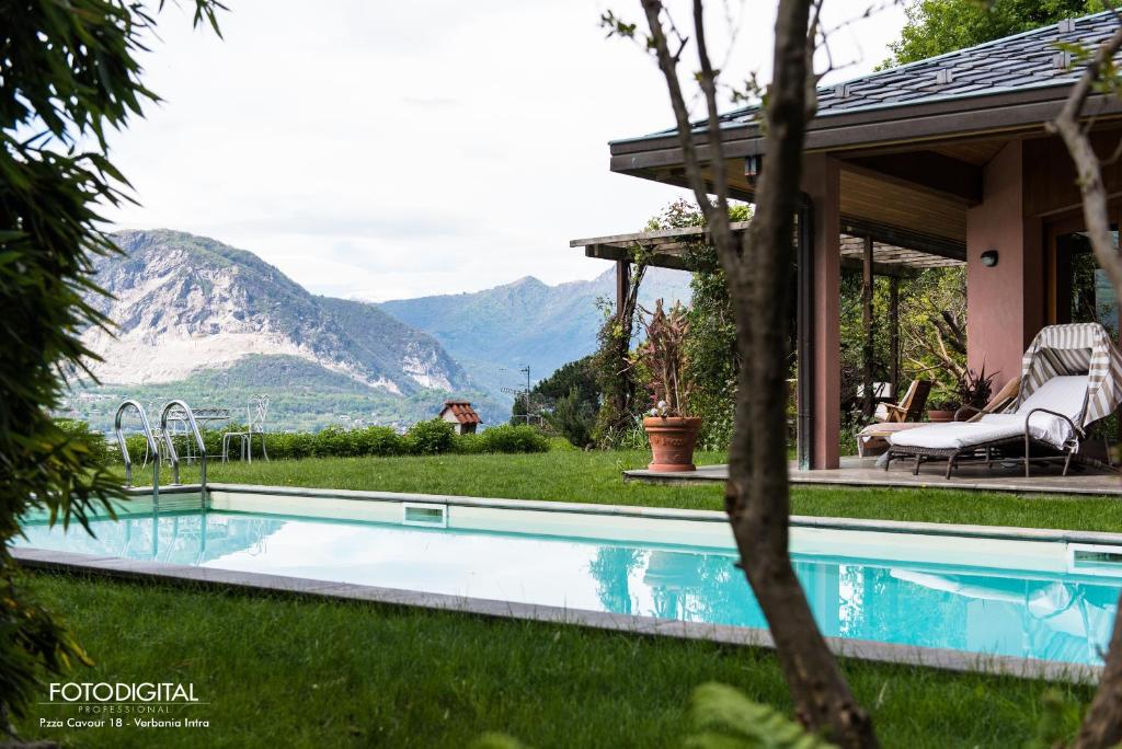 una piscina en un patio con montañas al fondo en B&B Renalù, en Verbania