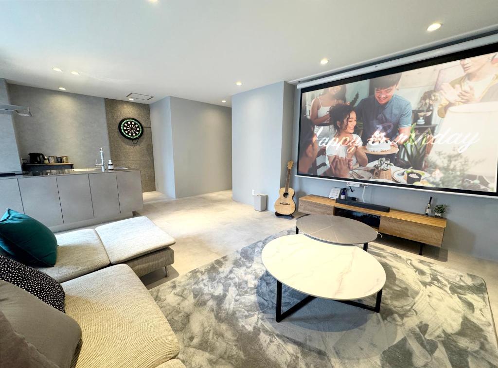 a living room with a large flat screen tv at TABISAI HOTEL Terrace 博多 in Fukuoka