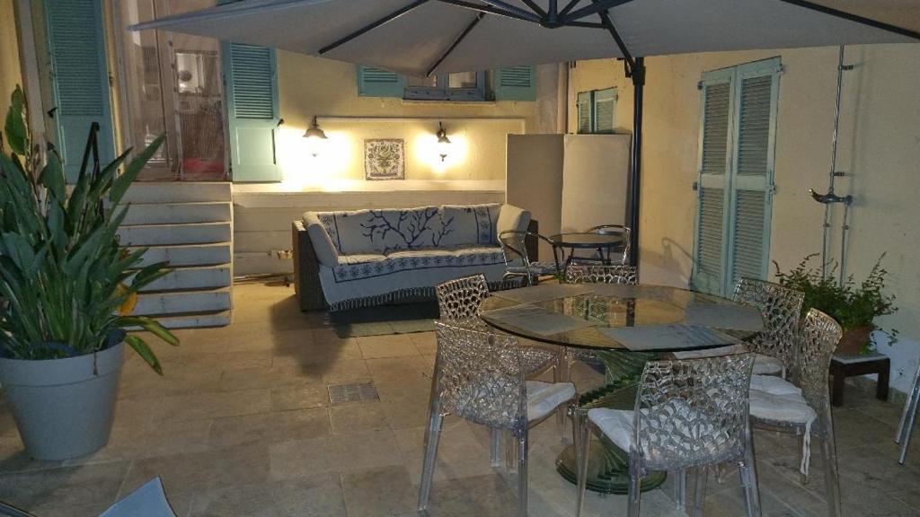 un patio avec une table, des chaises et un canapé dans l'établissement Exceptionnel Cannes Banane, appartement rénové dans ancien couvent 43m et Terrasse 48m, à Cannes
